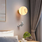 Glowing moon-shaped wall light with a tiny astronaut hanging above, celestial-themed design.