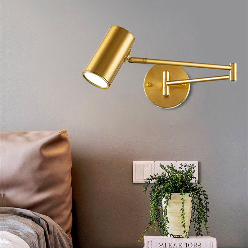 Gold aluminum wall light with adjustable arm, integrated mount, fixed on a light gray wall.