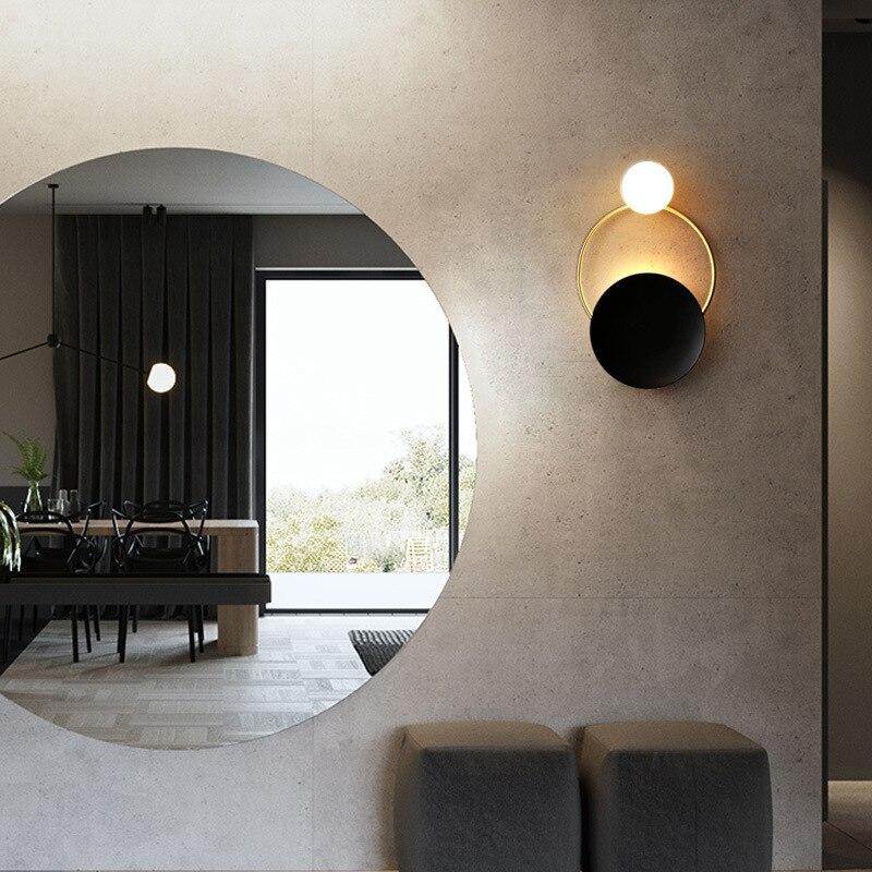 A Brushed Steel Circular Glass Wall Light glows softly against a minimalist, modern wall.