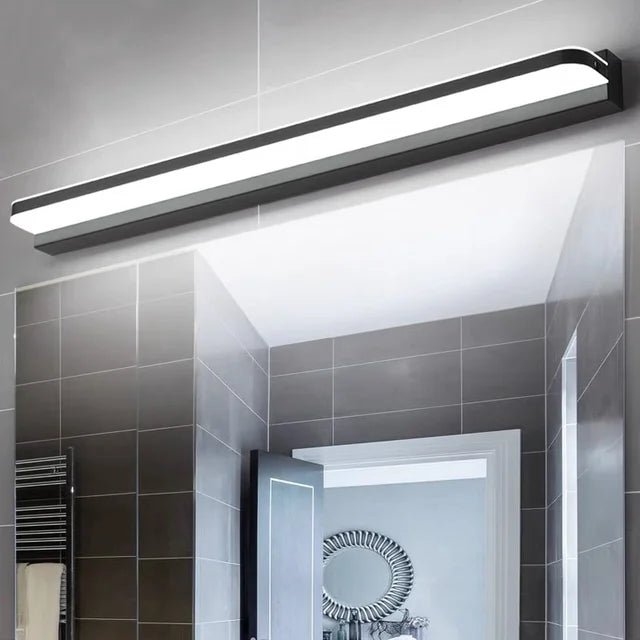 Luminaire mural LED design épuré en inox, éclairage blanc, fixé au-dessus d'un miroir.