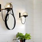 Industrial retro glass and metal ball wall light with sleek black hardware, soft warm glow.