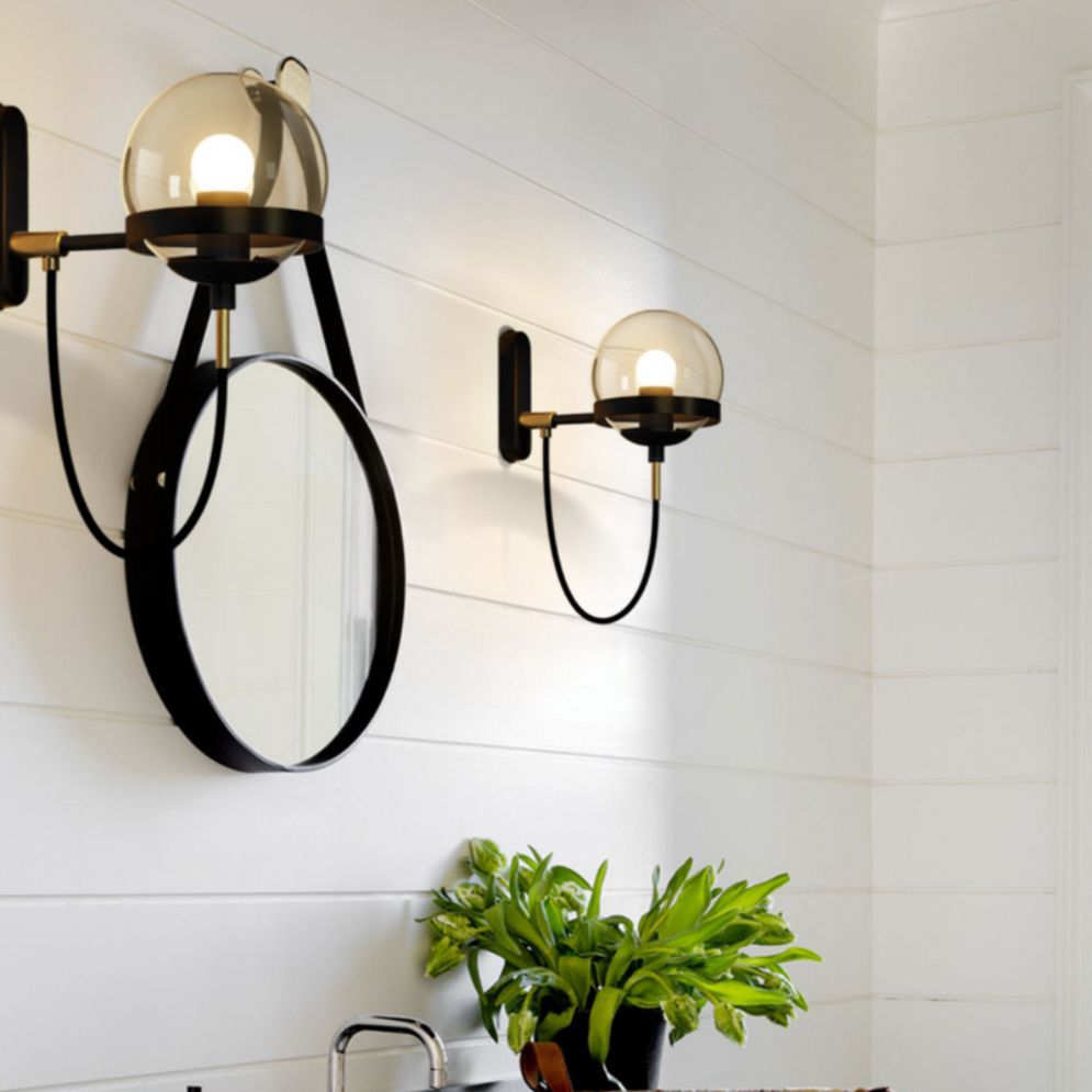 Industrial retro glass and metal ball wall light with sleek black hardware, soft warm glow.