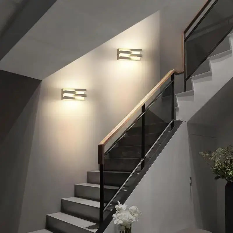 LED outdoor wall light fixtures made of aluminum and borosilicate glass illuminate the stairwell.