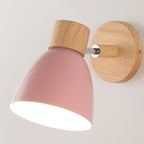 Light wood base, pink metal shade wall light, 360° rotation, emits warm glow.