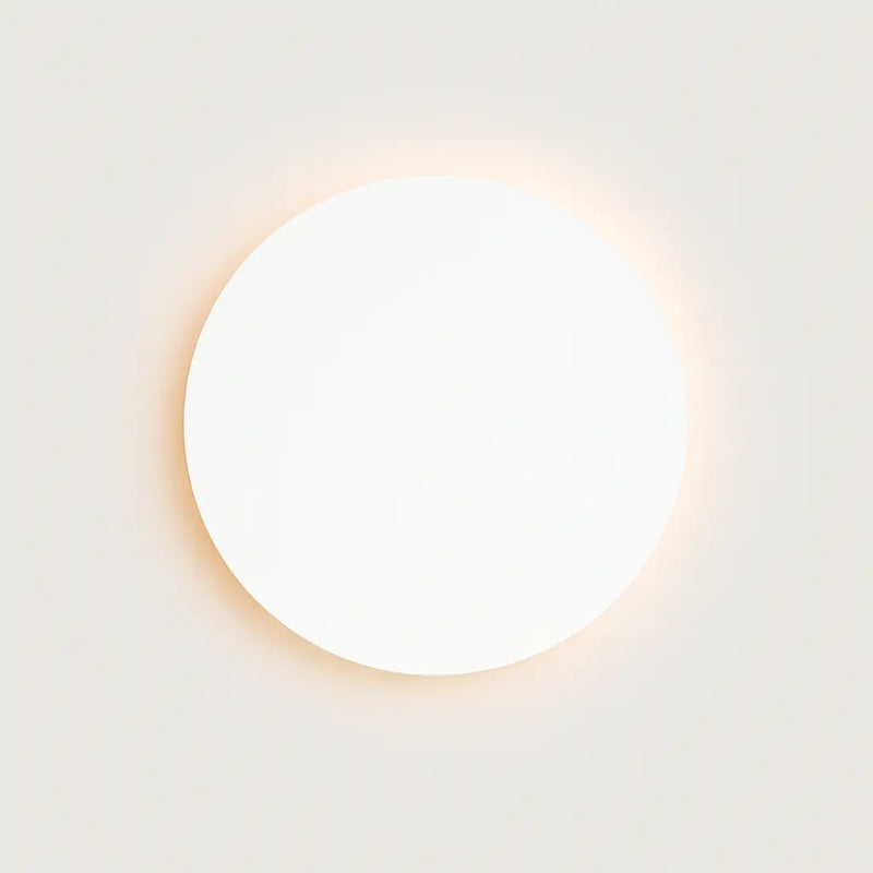 Minimalist Alloy Round LED Wall Light with gentle halo effect, softly illuminating the wall.
