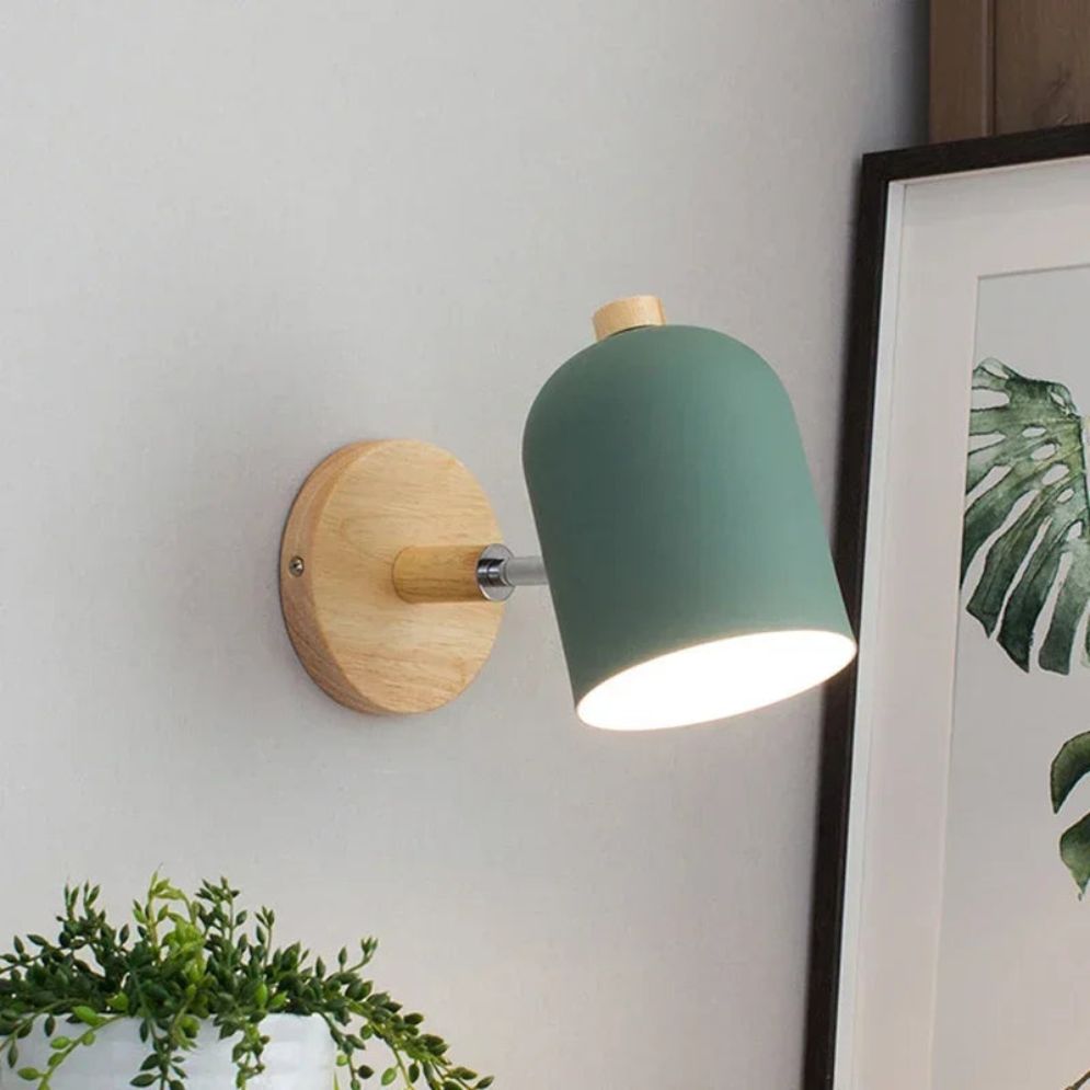 Minimalist wooden wall sconce with white metal LED ball turned on, casting soft light.