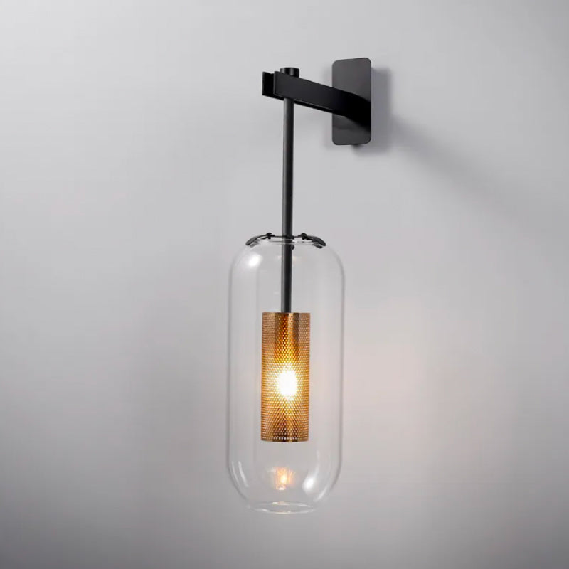 Modern black iron wall light with gold details, clear glass shade, and mesh bulb enclosure.