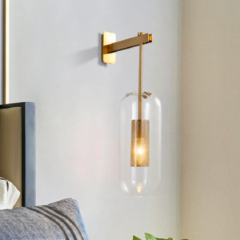 Modern gold and black wall light with cylindrical clear glass shade, E27 bulb compatible.
