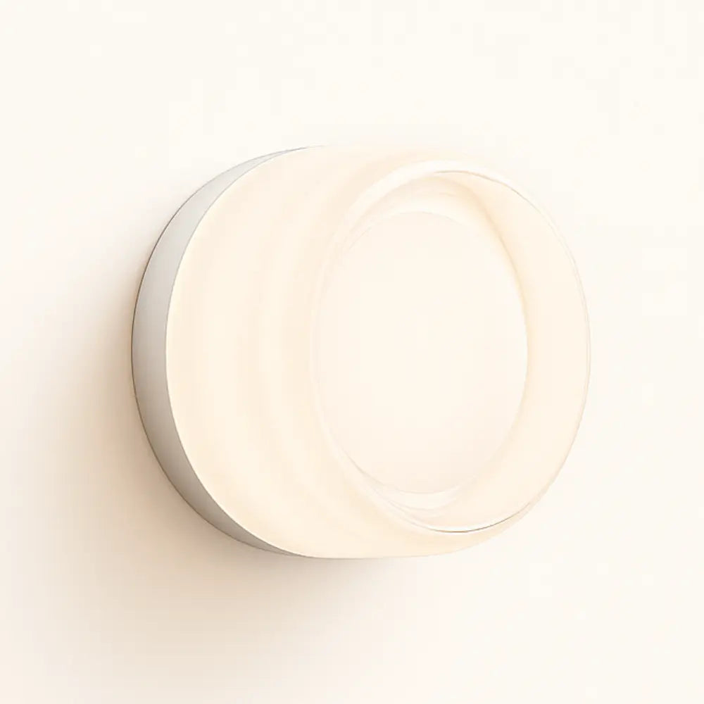 Modern round blown glass wall light with frosted white cover, emitting a soft glow.