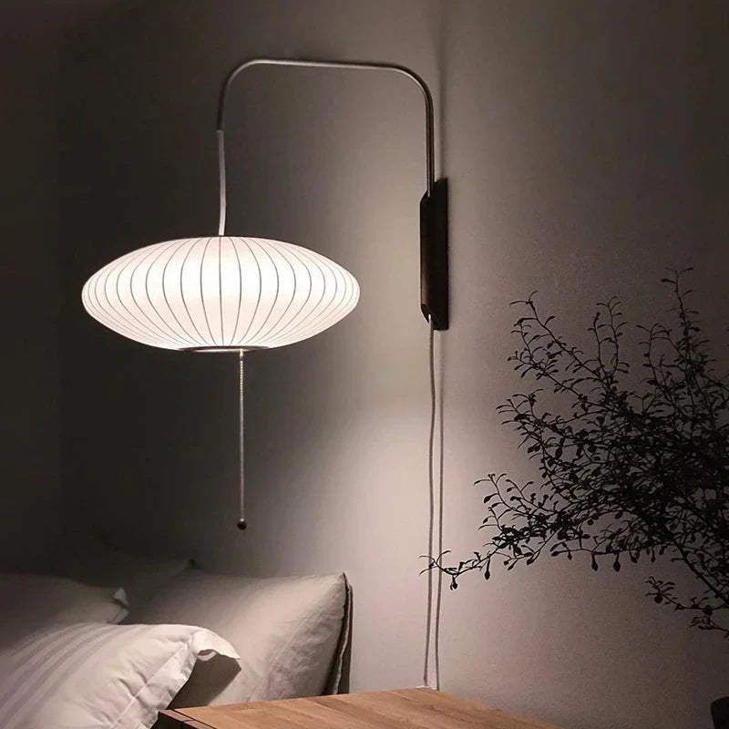 Applique murale boule design japonais soie et acier inoxydable diffusant une lumière douce.
