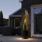 Outdoor LED Wall Sconce Metal mounted on exterior wall, softly illuminating the entryway.