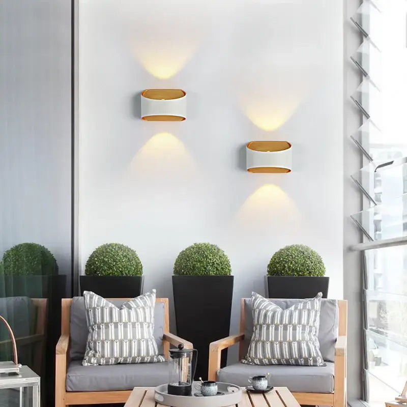 Rectangular aluminum outdoor wall light (IP65) with warm LED glow on a white wall.