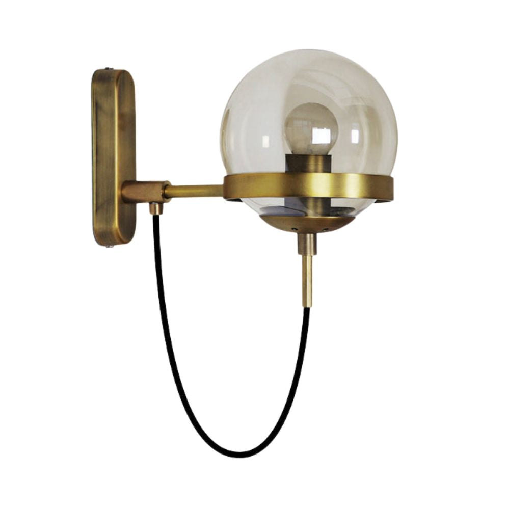 Round clear glass globe wall light with brass fixture, visible bulb, black cord, rectangular brass mount.