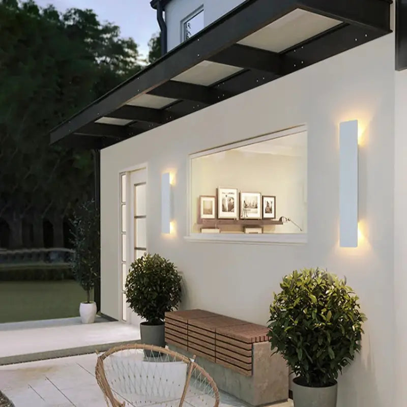 Simple, modern aluminum outdoor wall lights with clean lines mounted on a contemporary exterior wall.