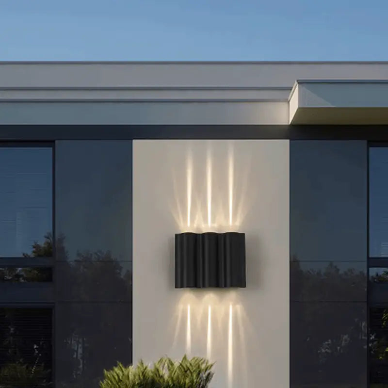 Sleek black aluminum wall light with curved design, casting multiple up-and-down LED beams.