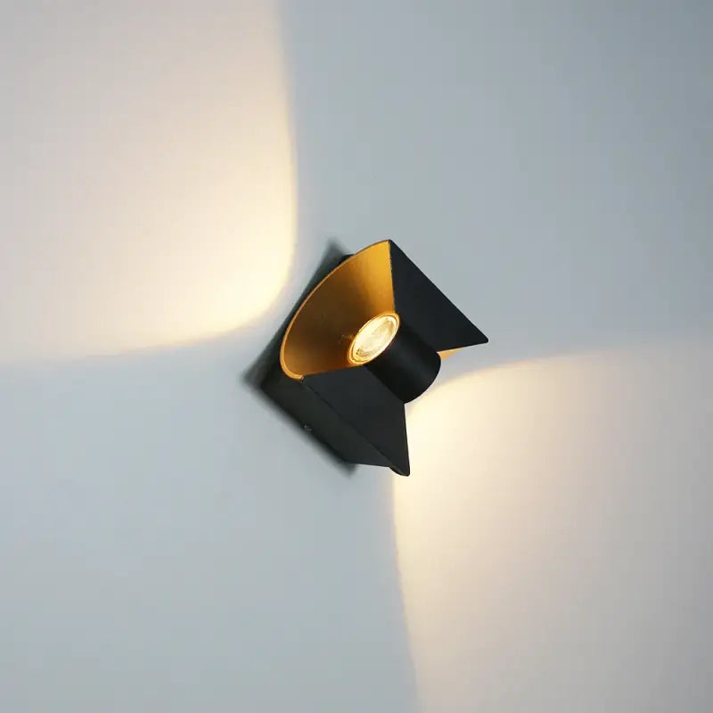 Sleek curved black LED wall light, aluminum, waterproof, casts dual-directional X-shaped beams.