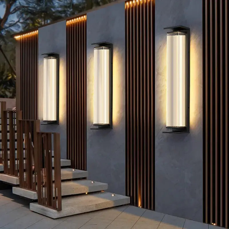 Sleek, vertical rectangular black glass wall light with IP65 protection and warm glow.