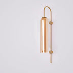 Sleek vertical rod with a cylindrical metallic shade forms this minimalist industrial glass wall light.