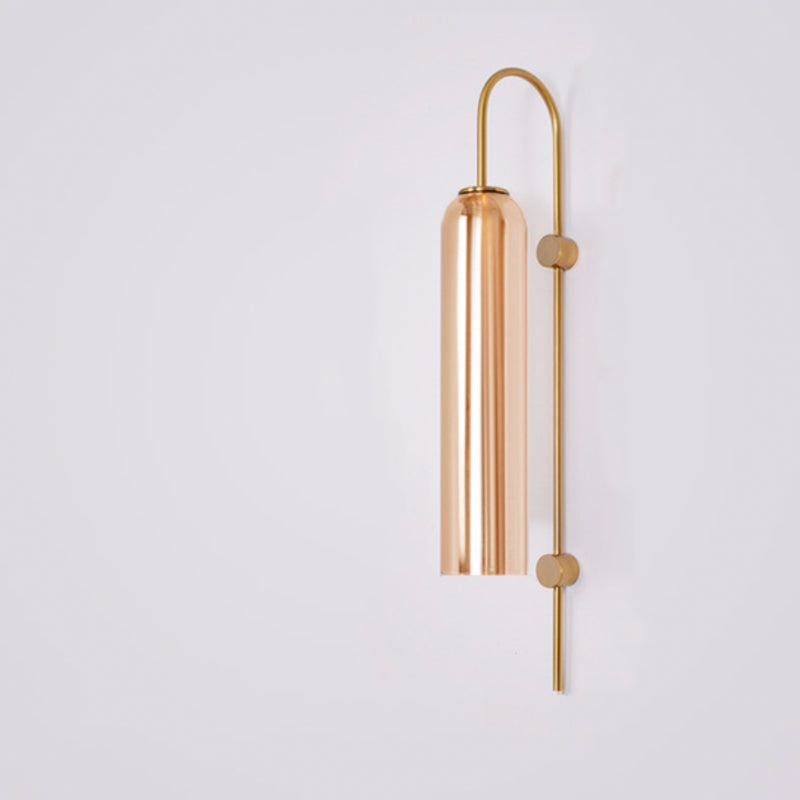 Sleek vertical rod with a cylindrical metallic shade forms this minimalist industrial glass wall light.