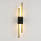 Sleek wall light with two gold rods and black center, softly glowing from behind.