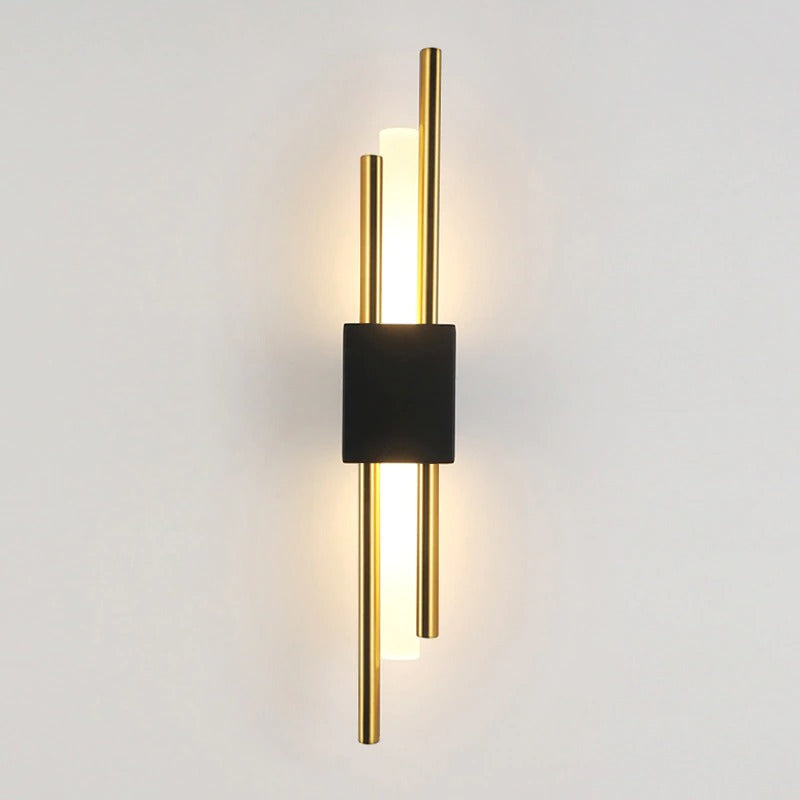 Sleek wall light with two gold rods and black center, softly glowing from behind.