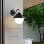 The Modern Black Outdoor Wall Light with conical shade and glowing round bulb, white glass.