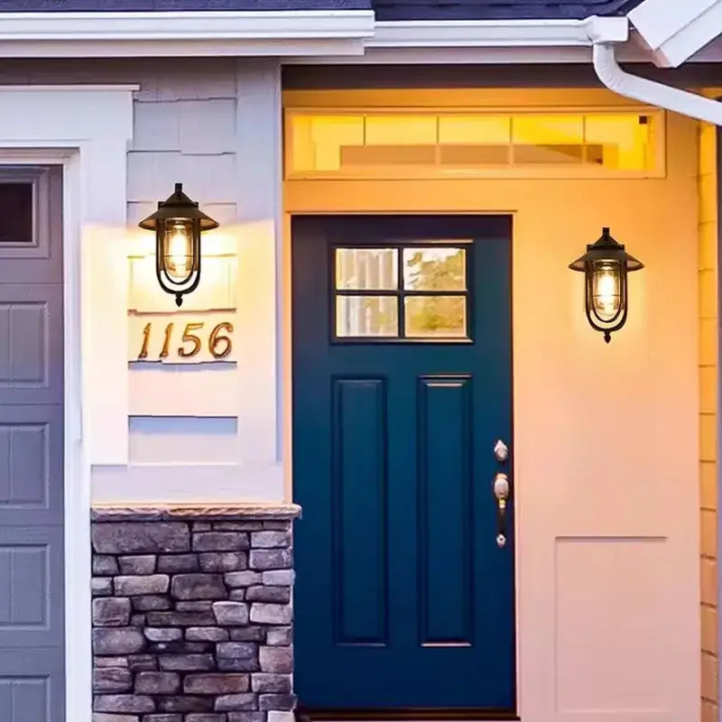 Two Outdoor Waterproof Metal Lantern Wall Sconces (IP65) emitting warm yellow light at entryway.