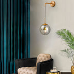 Tyla Modern Metal Glass Wall Sconce in black and gold, mounted for stylish illumination.