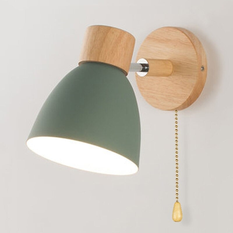Wooden-based, green-shaded wall light with 360° rotation and pull chain switch for adjustable illumination.