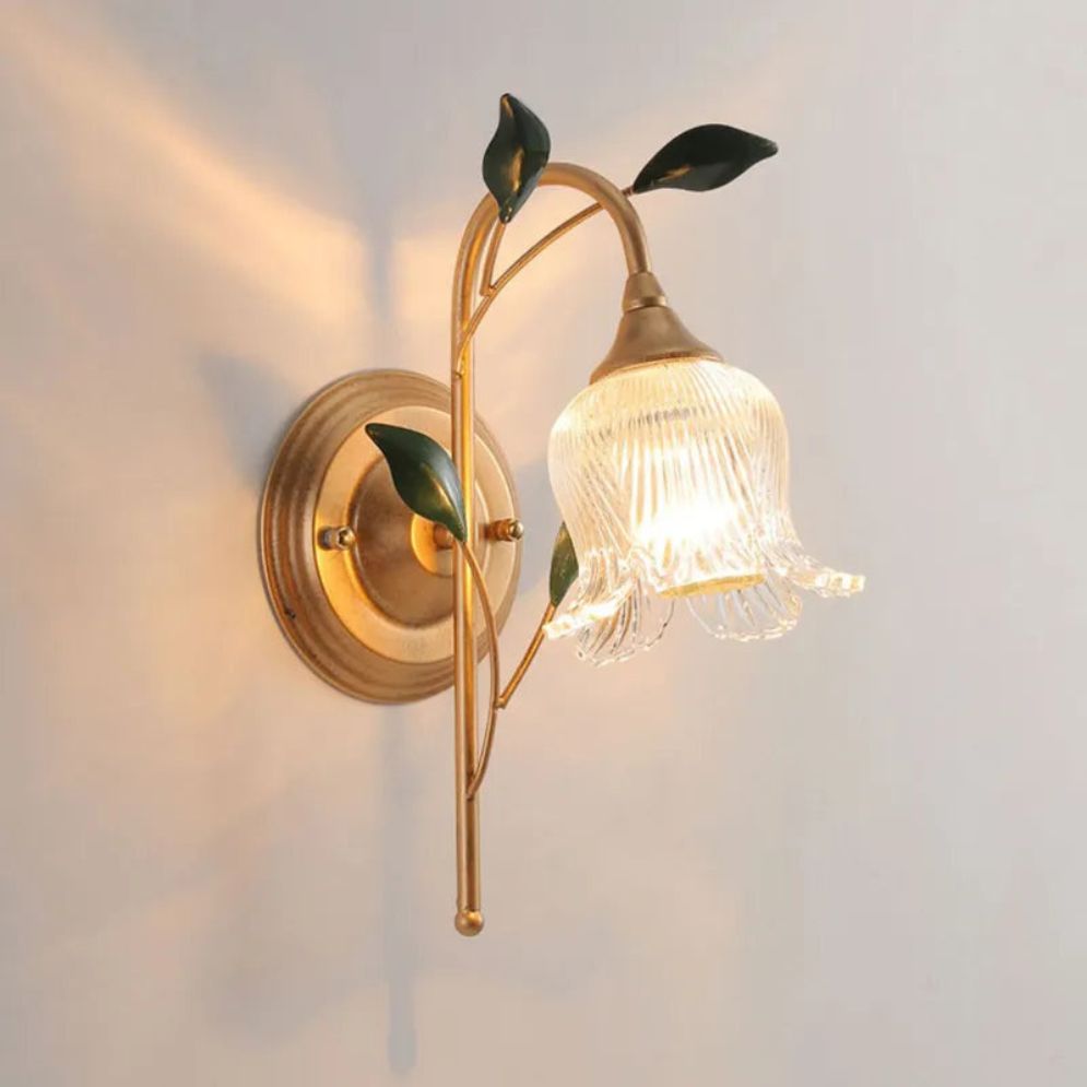 Golden leaves and flower-glass globe create a warm, elegant wall lighting accent.