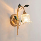 Golden leaves and flower-glass globe create a warm, elegant wall lighting accent.