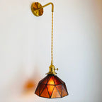 Warm amber and red stained glass radiates a modern, elegant glow on white walls.