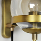 Crisp light glows through a clear glass globe with brass hardware, beautifully illuminating space.