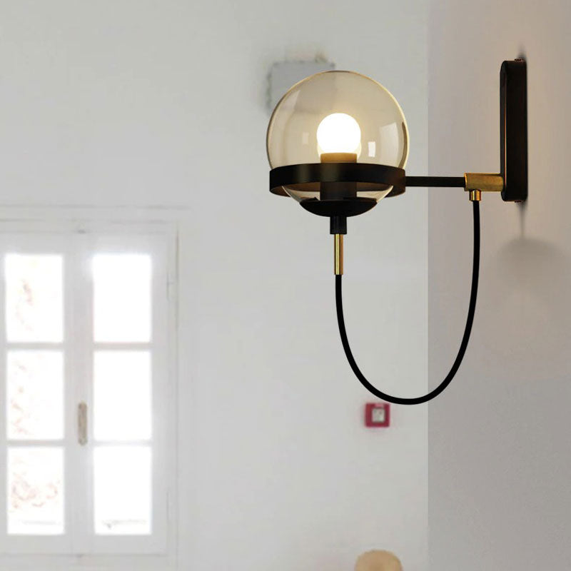 This industrial glass wall light delivers bright, modern illumination with its exposed bulb and round shade.