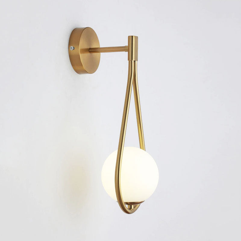 The LED wall light provides soft, elegant illumination with its brass base and frosted globe.