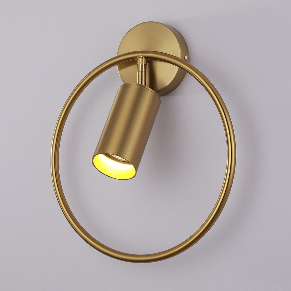 Elegant circular gold LED wall light casts focused illumination with a unique modern ring design.