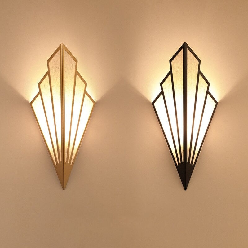Warm accent lighting fans out on beige walls from black-gold triangular wall lights.