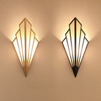 Warm accent lighting fans out on beige walls from black-gold triangular wall lights.