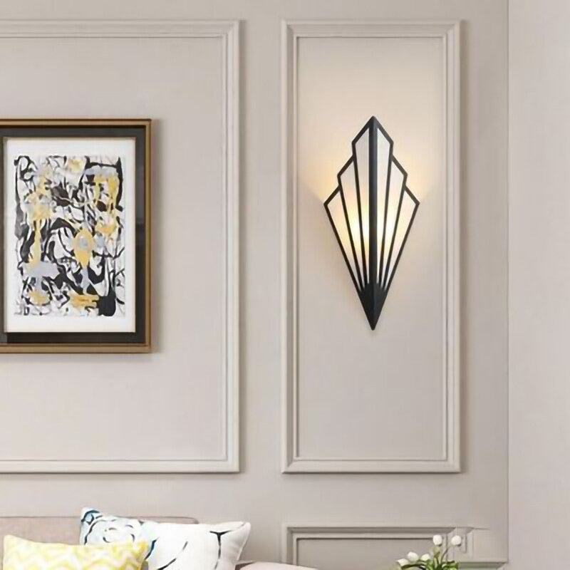 Warm accent lighting glows from a geometric, art deco-inspired black gold linen wall fixture.