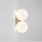 Two globe lights on a gold base offer elegant, minimalist illumination for any kitchen.
