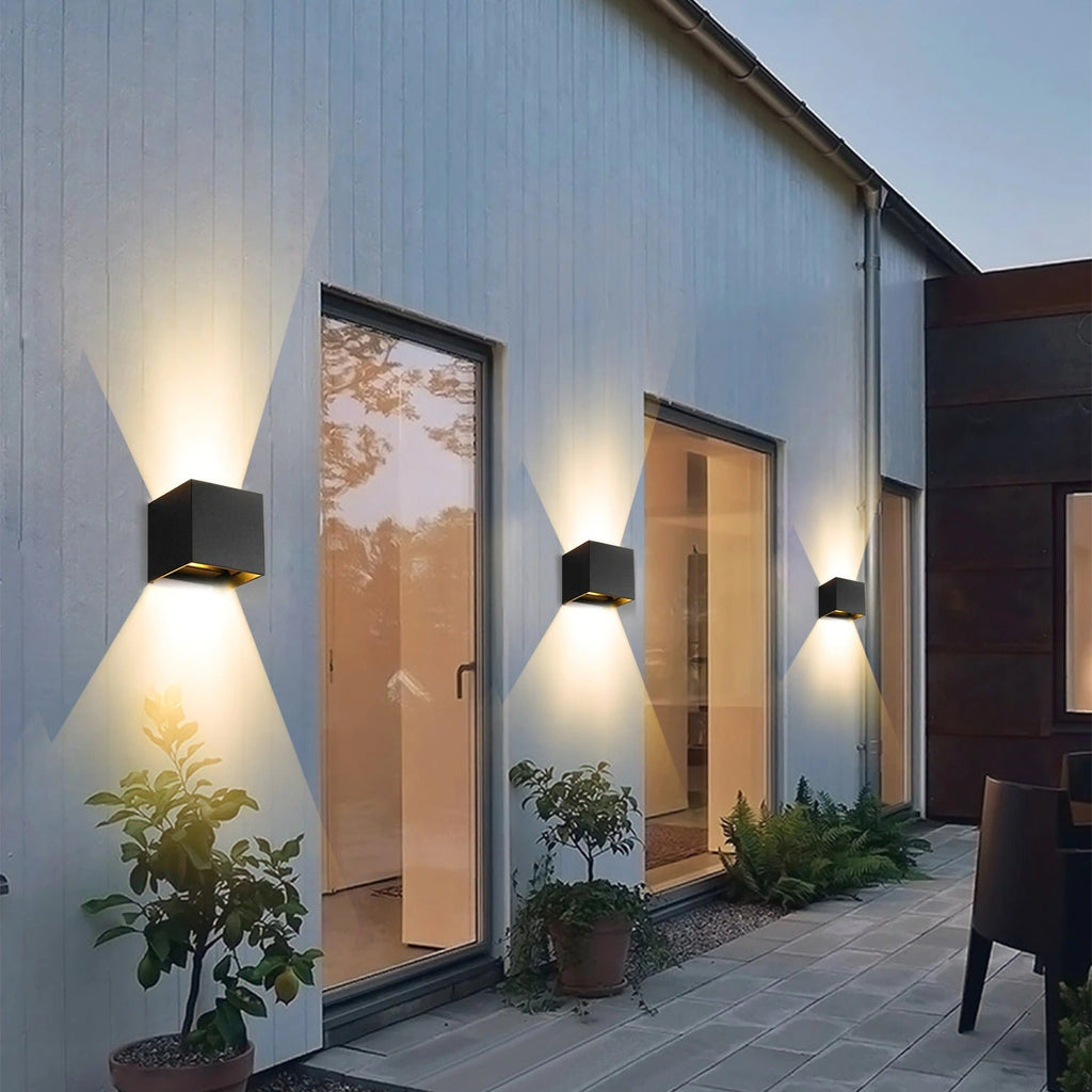 The ORLUNE HOME LED Cube Wall Light casts a striking X-shaped glow at dusk.