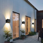 The ORLUNE HOME LED Cube Wall Light casts a striking X-shaped glow at dusk.