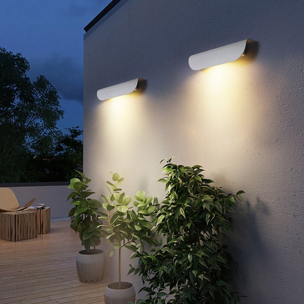 At dusk, wave-patterned LED wall lights cast a gentle glow, enhancing outdoor ambiance.