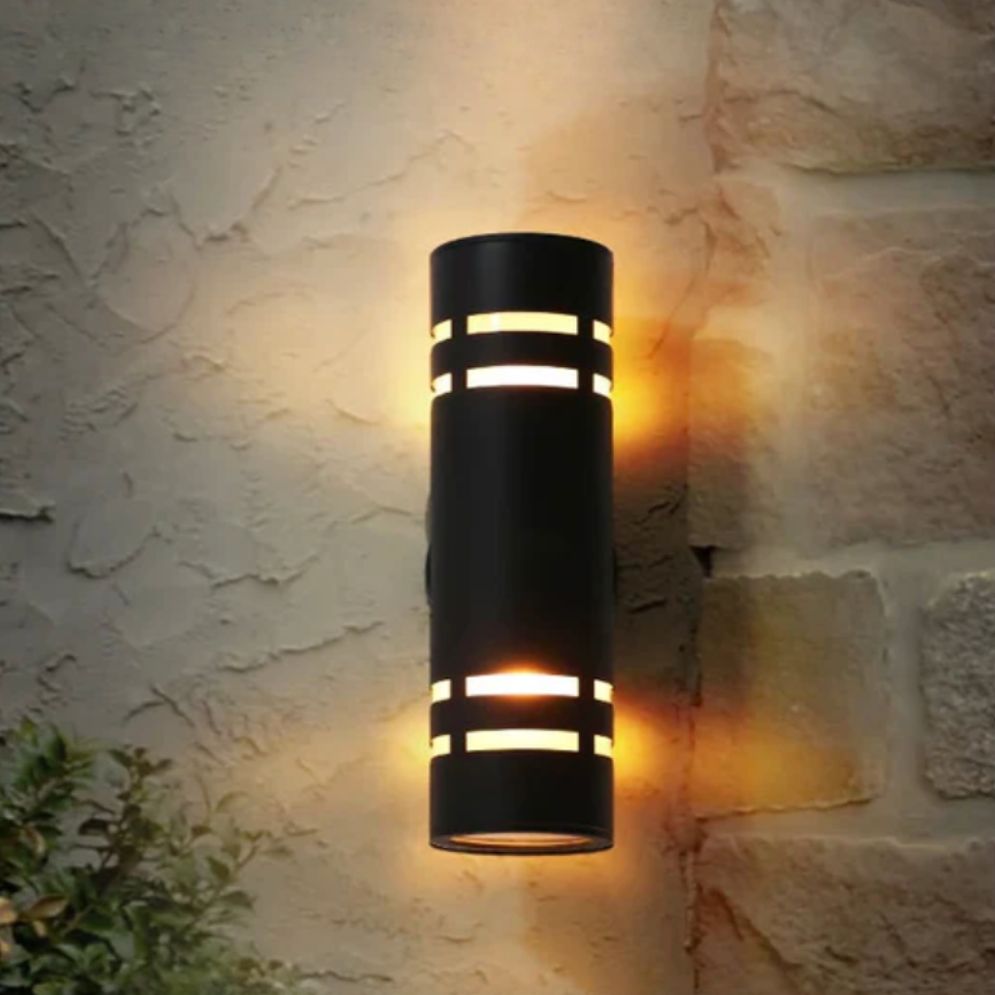 Warm LED light glows softly from top and bottom of the sleek black wall fixture.