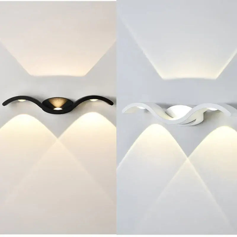 Deux appliques murales LED vagues noires et blanches diffusent une lumière graphique symétrique.
