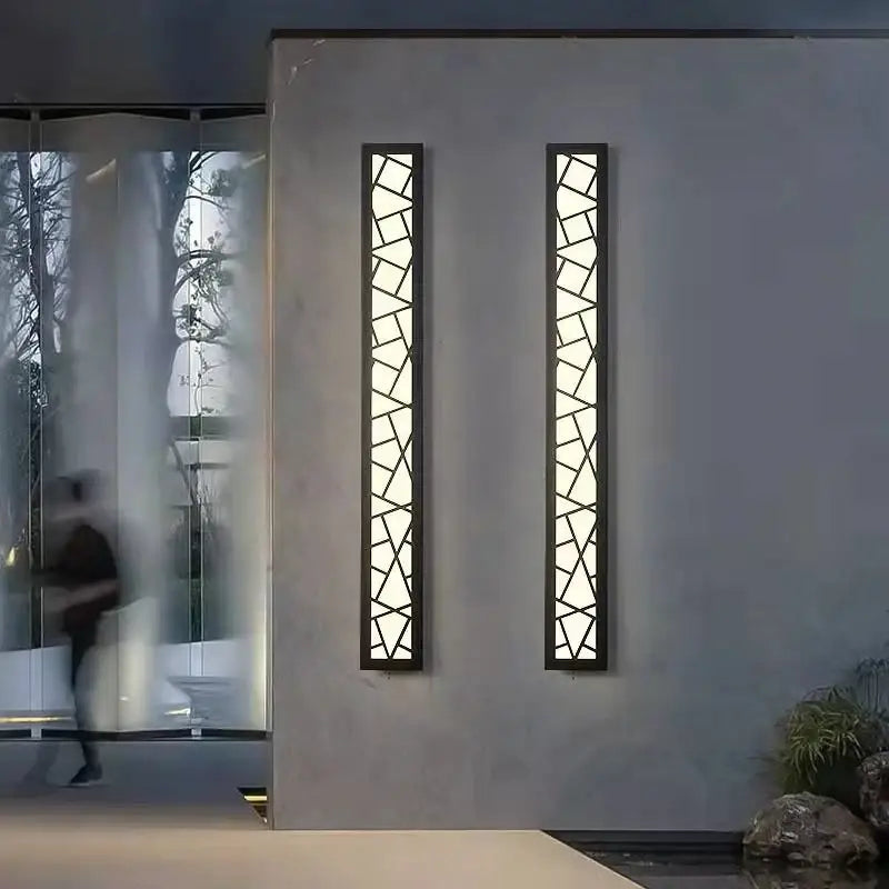 Deux appliques murales géométriques en aluminium à design moderne fixées sur un mur gris.