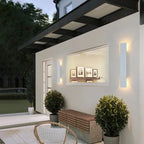 Deux appliques murales épurées en aluminium noir fixées sur un mur extérieur blanc.