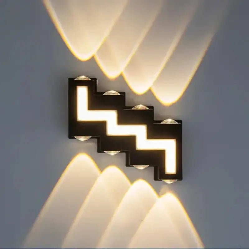 Luminaire noir zigzag LED, éclaire symétriquement vers le haut et bas avec lumière chaude.