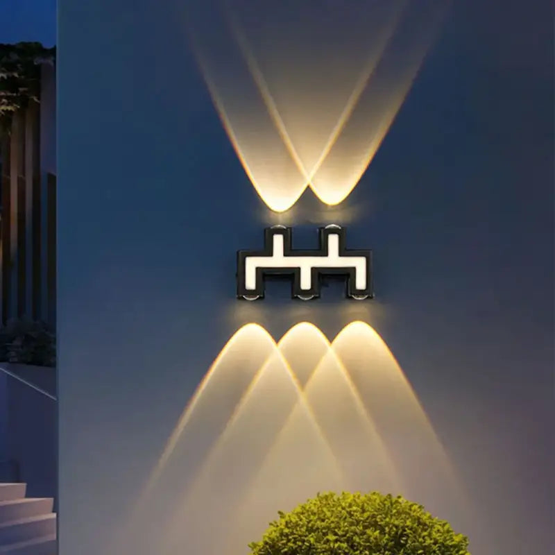 Luminaire mural LED en aluminium projetant une lumière chaude et motifs géométriques zigzag.