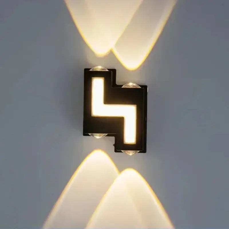 Applique murale LED noire, lumière chaude haut/bas, motifs triangulaires, style contemporain.